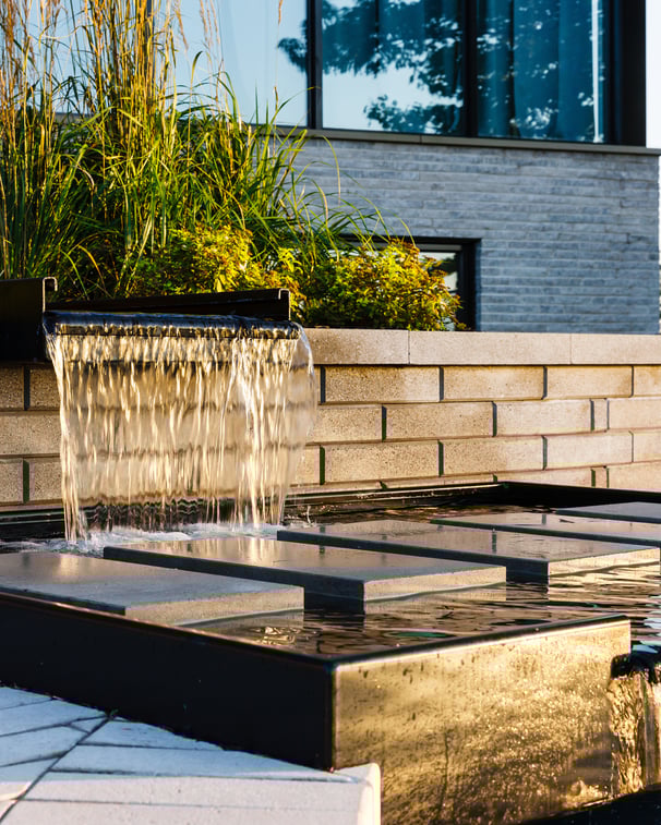 Backyard water fountain featuring Techo-Bloc's Raffinato Smooth retaining wall
