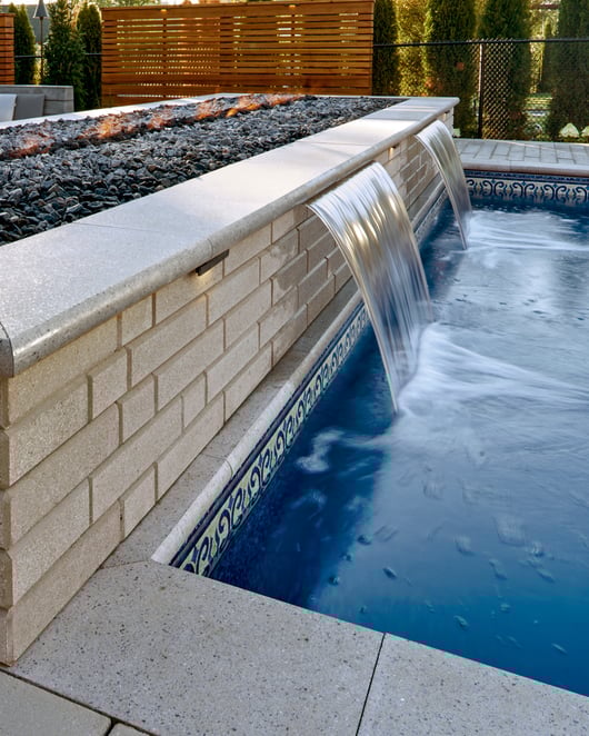 Techo-Bloc's Raffinato Smooth retaining walls used for a backyard fire pit and a waterfall. 