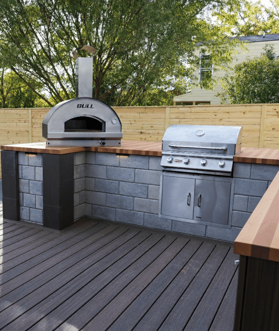 Outdoor kitchen with Techo-Bloc's Raffinato Smooth retaining wall and a wood countertop
