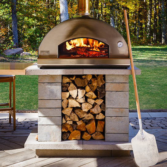 Techo-Bloc's Forno pizza oven seen in a backyard outdoor kitchen. 