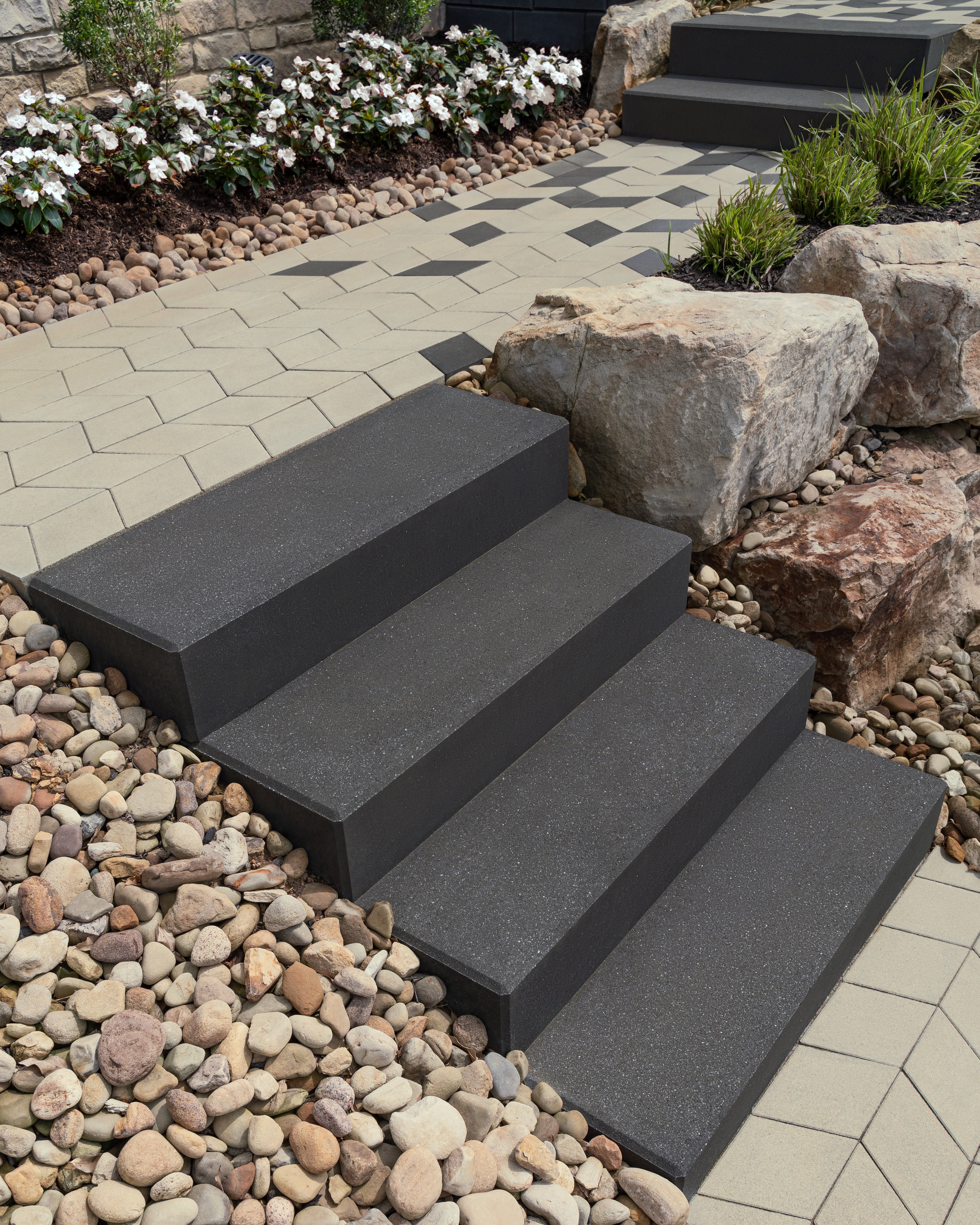 Front yard walkway featuring Techo-Bloc's Diamond pavers, Raffinato steps, and river rocks