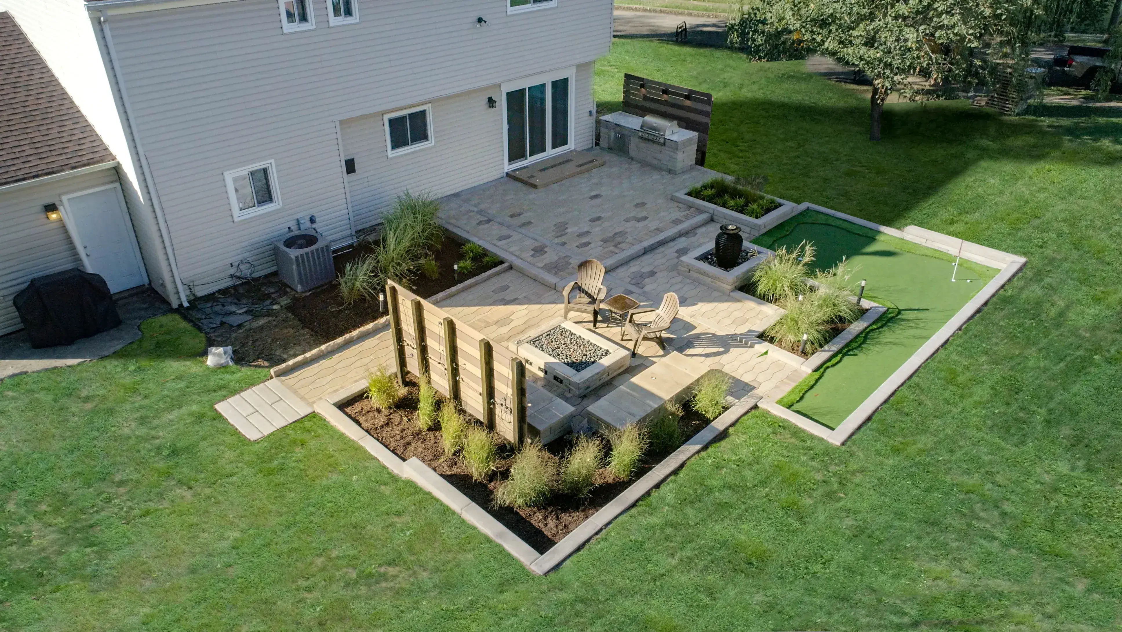 Backyard landscape with fire pit, grill island and intamicy wall